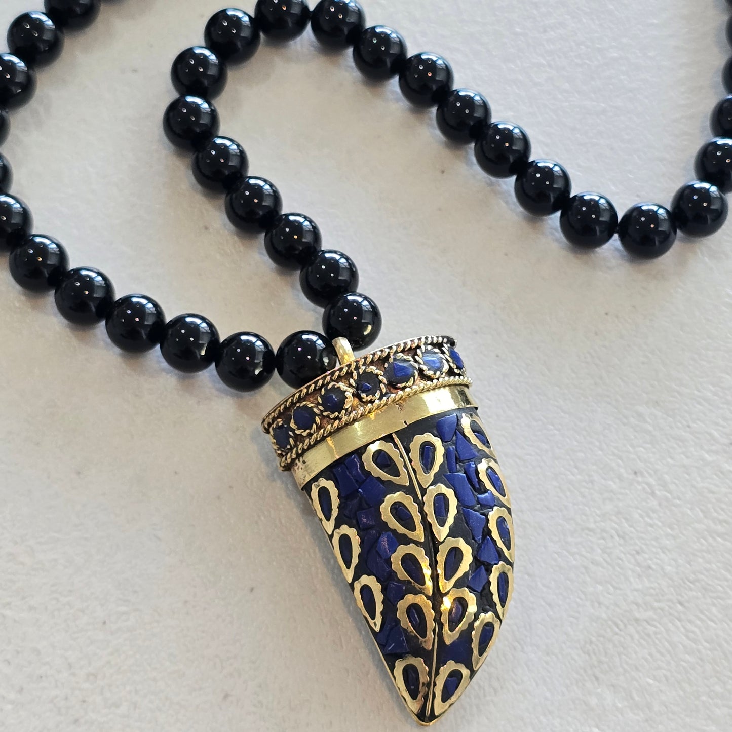Colmillo tibetano azul rey con obsidiana